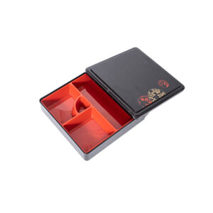 This is a traditional Japanese-style bento box, featuring a sleek black lid with elegant red and gold floral patterns and a vibrant red multi-compartment interior. Crafted from durable, food-safe plastic/melamine, it keeps different food items neatly separated while adding a touch of cultural charm to meal presentations. Ideal for both commercial food service and personal use, it combines functionality with a classic aesthetic.